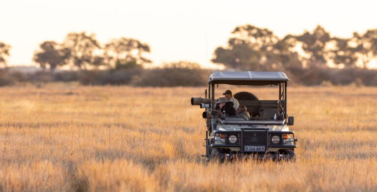 Photographe à bord d'un 4x4 équipé de gros objectifs